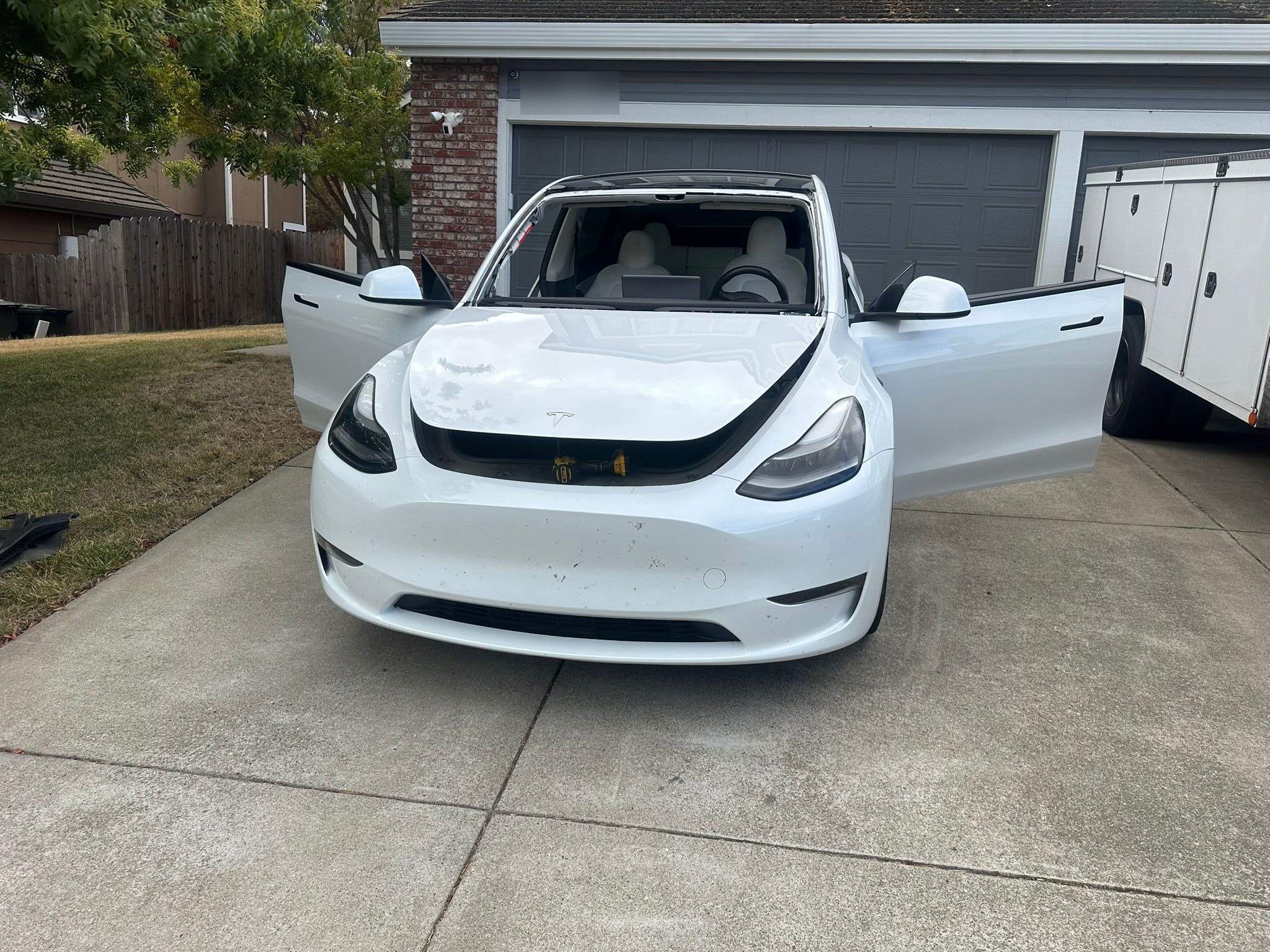 White Tesla Model Y in driveway during mobile windshield replacement service by Auto Glass of Bellevue